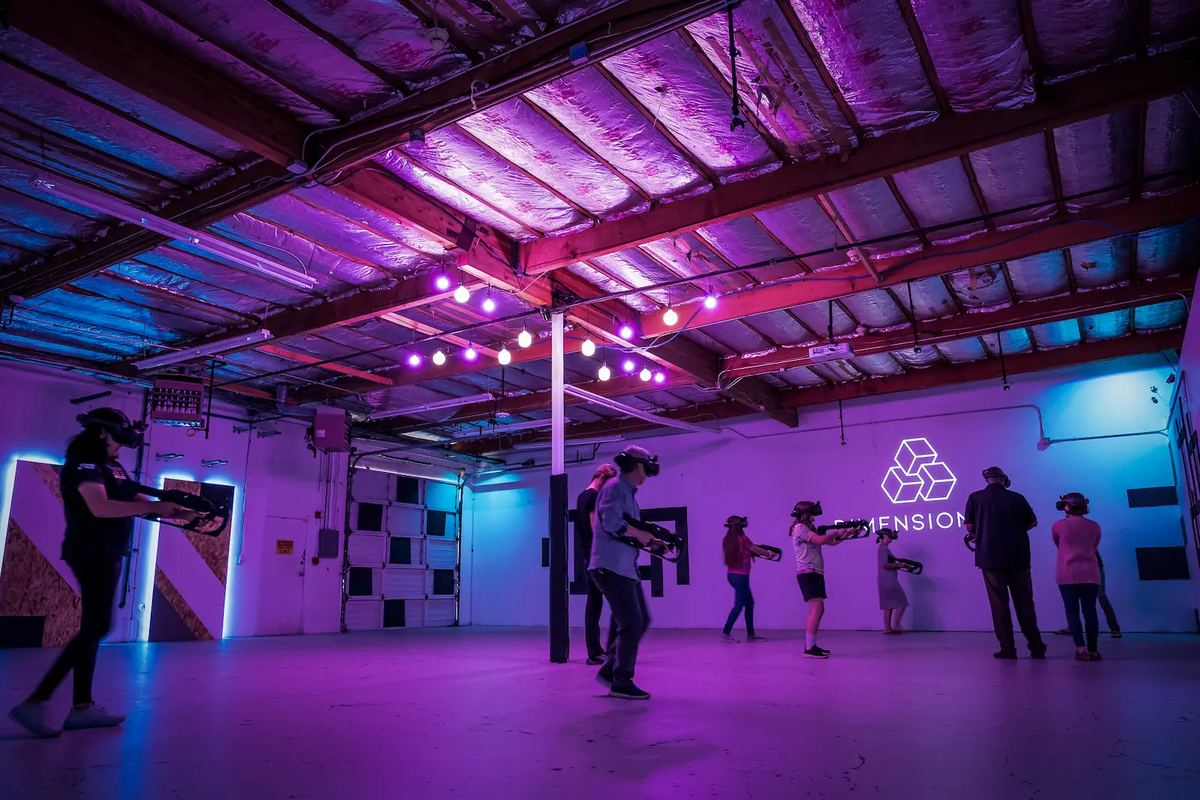 Players with headsets and blasters spread across the large purple-lit Tukwila arena under strings of lights.