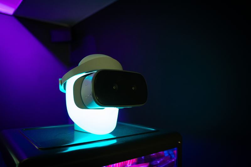 A white VR headset on a glowing display stand.
