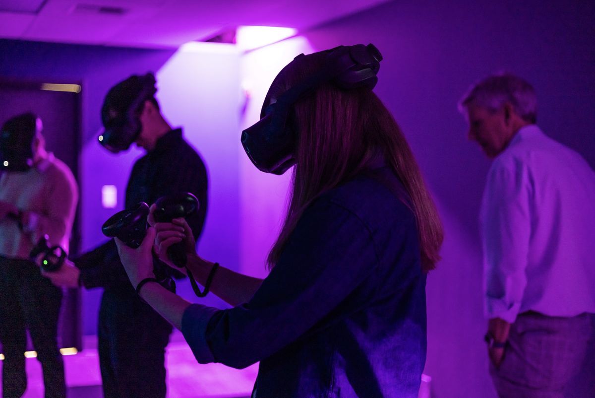 A player in a VR headset and controllers under purple light in the Tukwila arena.